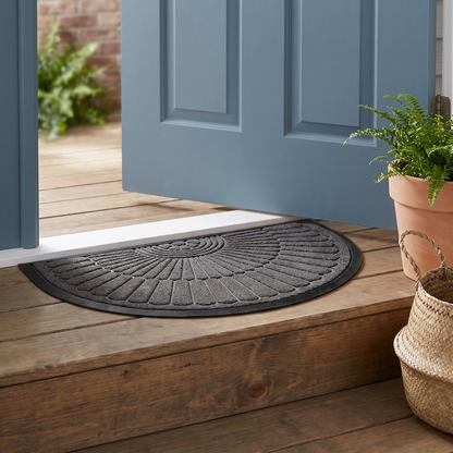 Semi-circle rubber door mat placed in front of an entryway door
