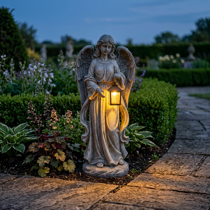 Angel solar pathway light glowing in a garden bed at dusk