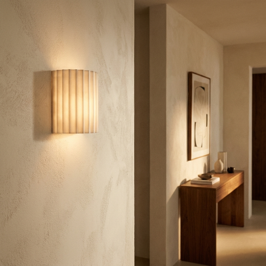 Resin wall lamp casting a warm glow in a modern hallway