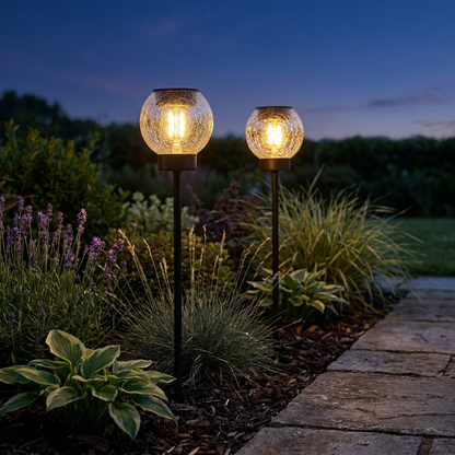Solar crackle ball stake lights glowing in a garden border